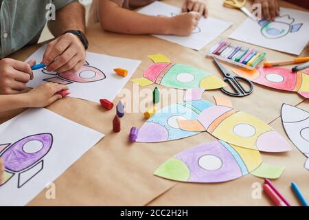 Nahaufnahme von nicht erkennbaren Kindern zeichnen Bilder von Weltraumraketen, während genießen Kunst-Klasse in der Vorschule oder Entwicklungszentrum, kopieren Raum Stockfoto