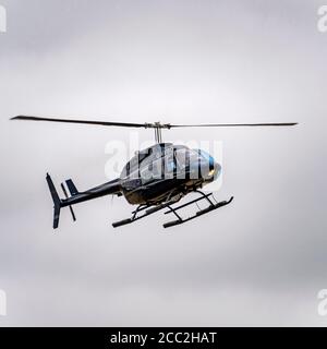 Quadratische Nahaufnahme eines Bell 206 Hubschraubers, der an Land kommt. Stockfoto