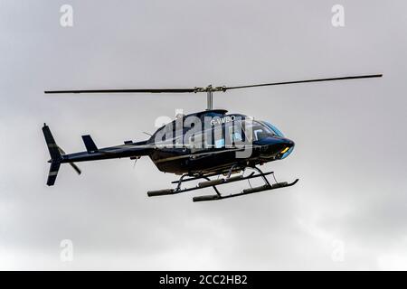 Horizontale Nahaufnahme eines Bell 206 Hubschraubers, der an Land kommt. Stockfoto