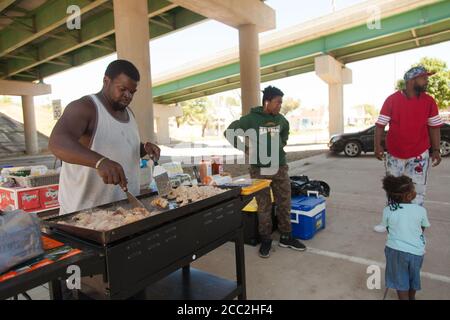 Cedar Rapids, Iowa, USA. August 2020. 15. Aug. 2020: Jovountae Robinson kocht Mahlzeiten unter einer Überführung für jeden, der etwas zu essen braucht. Er ist nur eine Einzelperson, die versucht, dem coummunity so gut er kann zu helfen. Cedar Rapids und viele der umliegenden Grafschaften wurden am 10. August von einem Derecho getroffen. Fast eine Woche später, und viele Menschen sind immer noch ohne Strom, einige schlafen in Zelten und Plätze ohne Klimaanlage und Warmwasser, in der Hoffnung, die Nation wird Aufmerksamkeit auf das, was dort geschieht zu zahlen. Die Gemeinschaft hat sich versammelt, um einander zu helfen, da sie sehr wenig empfangen Stockfoto