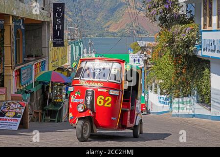 Rot gefärbtes Tuk-Tuk / mototaxi in der Stadt San Pedro La Laguna in der Nähe des Lago de Atitlán / Atitlan-See, Sololá Department, Guatemala, Mittelamerika Stockfoto