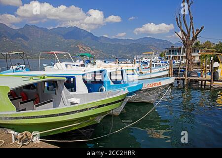 Touristenboote im kleinen Hafen von Santiago Atitlán am Ufer des Lago de Atitlán / Atitlán-See, Departement Sololá, Guatemala, Zentralamerika Stockfoto