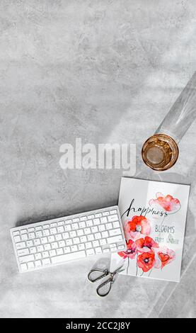 Styled Schreibtisch mit Tastatur und Glas Wasser, Kopierraum, vertikal, grauen Stein Hintergrund, minimale Zusammensetzung Stockfoto