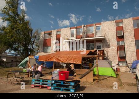 Cedar Rapids, Iowa, USA. August 2020. 16. August 2020: Mitglieder der Phillips und Salvador Familien haben ihre Küche und Wohnzimmer außerhalb ihrer Wohnung eingerichtet, seit ihr Gebäude verurteilt wurde. Cedar Terrace Apartments, eine Gemeinschaft von vielen, die Flüchtlinge in ihrem eigenen Land waren, wurde während des Sturms, der die Gegend am Montag, den 10. August heimgesucht hatte, verschlingt. Viele der Gebäude sind verurteilt, so dass die Bewohner draußen in Zelten schlafen. Nachdem die Lokalnachrichten erschienen sind, kommen Spenden und die Feuerwehr versucht, so viele wie möglich in Unterstände zu stecken. Schade Stockfoto