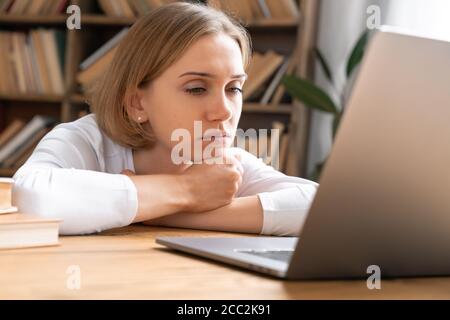 Erschöpft junges Mädchen ist online zu Hause mit einem Laptop zu studieren. Stockfoto