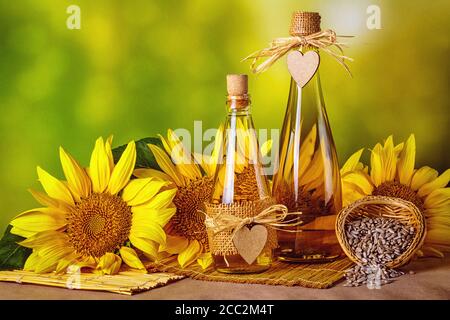 Ländliche Stillleben - Sonnenblumenöl in Flaschen mit Blüten der Sonnenblume (Helianthus annuus), Nahaufnahme Stockfoto