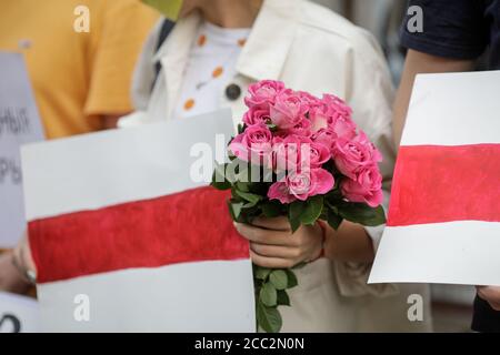 Bukarest, Rumänien - 16. August 2020: Details mit Menschen, die während einer politischen Kundgebung, die die Proteste in Belarus unterstützt, Banner und Blumen halten. Stockfoto