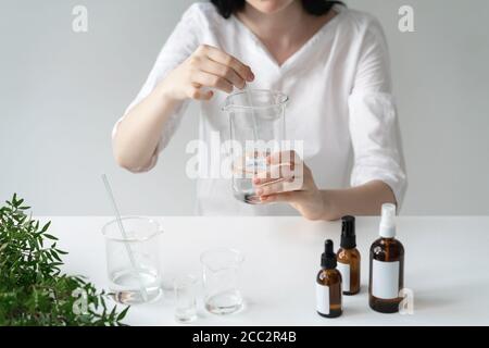 Der Wissenschaftler, Dermatologe testet das organische Naturkosmetikprodukt im Labor. Fläschchen, Laborflaschen aus Glas. Kosmetische Forschung Stockfoto
