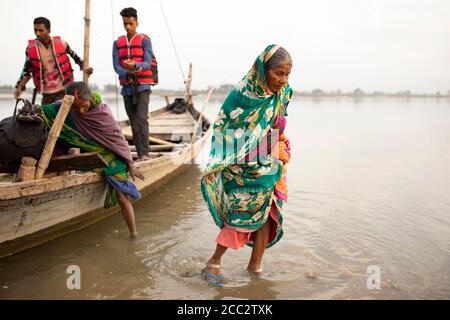 Frauen werden mit dem Boot aus einem überfluteten Gebiet an der Grenze zwischen Indien und Nepal evakuiert. Stockfoto