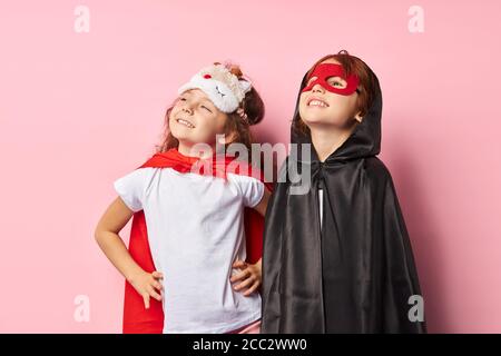 Mädchen und Jungen Superhelden Porträt. Kind Junge trägt schwarzen Mantel, Mädchen in roten Mantel. Stockfoto