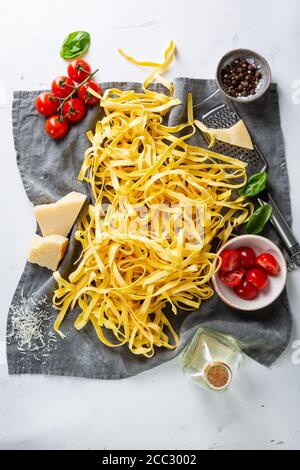 Rohe fettuccini Pasta und Soße Zutaten auf grauen Küchentuch Stockfoto