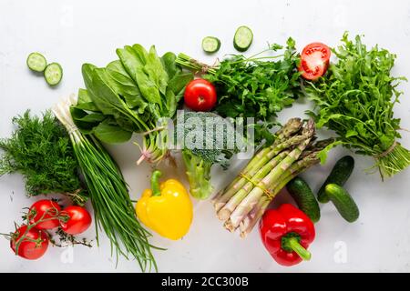 Frisches grünes Gemüse und Sommerprodukte auf weißer Oberfläche Stockfoto