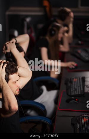 Schockiert überrascht eSport Gamer spielen in wettbewerbsfähigen Spiel in Gaming club legte ihren Kopf in die Hände in überwältigender Freude Erkennen, dass sie wo haben Stockfoto