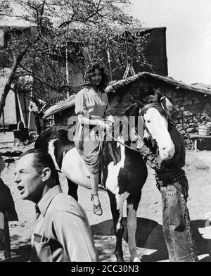 JENNIFER JONES auf Pferd und teilweise versteckt GREGORY PECK am Drehort offen während der Dreharbeiten zum DUELL IN DER SONNE 1946 Regisseure KÖNIG VIDOR OTTO BROWER WILLIAM DIETERLE SIDNEY FRANKLIN WILLIAM CAMERON MENZIES DAVID O. SELZNICK und JOSEF von STERNBERG Roman Niven Busch Drehbuch David O. Selznick Kostümbild Walter Plunkett Selznick International Pictures / Vanguard Films / Selznick Releasing Organization Stockfoto