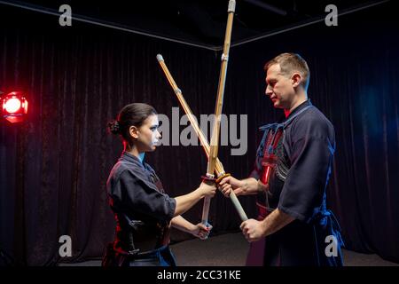 Zwei Kendo Kämpfer üben Kenjutsu, japanische Kampfkunst mit Samurai Schwerter. Menschen kämpfen Stockfoto