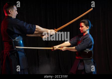 Zwei Kendo Kämpfer üben Kenjutsu, japanische Kampfkunst mit Samurai Schwerter. Menschen kämpfen Stockfoto