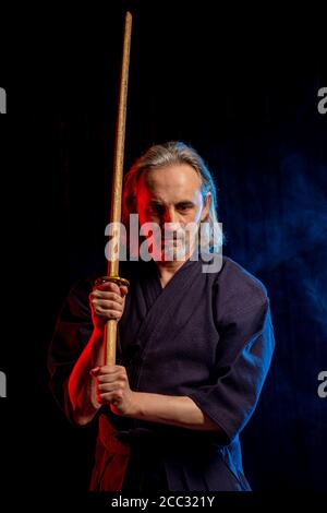 Porträt des kaukasischen starken Mann Kendo Kämpfer mit Bokuto. kendo Krieger männlich hält Samurai Schwert Katana Stockfoto