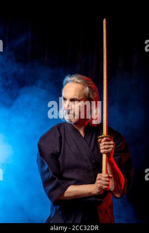 Porträt des kaukasischen Mann Kendo Kämpfer mit Bokuto Bambus Schwert Shinai . Japanische traditionelle Kampfkunst, Schutz, Aktivitätskonzept Stockfoto