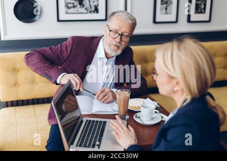 Neue Kollegen Beratung mit erfahrenen Koch. Nahaufnahme Foto. Mann mit Wissen oder Informationen mit einer Frau teilen Stockfoto