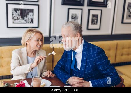 Schöne Frau hält eine Gabel mit Kuchen und gehen, um es einem Mann zu geben. Nahaufnahme Foto. Stockfoto