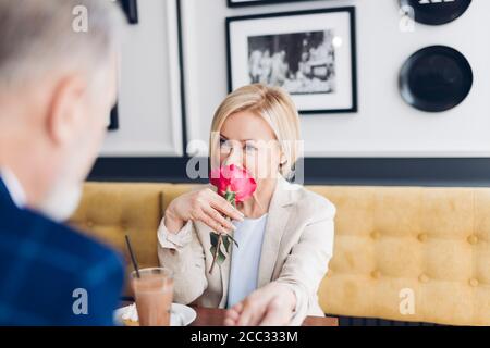 Gentleman Komplimente an blonde attraktive Frau und zeigt sein warmes Gefühl beim Frühstück im Café. Der Geruch der Liebe Stockfoto