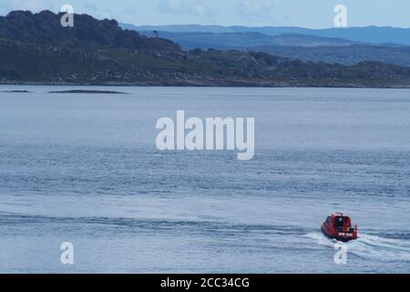 Ein kleines, tourend, Motorboot, das Passagiere auf einer Vergnügungskreuzfahrt um die Inseln im Sound of Jura an einem ruhigen Sommertag befördert Stockfoto