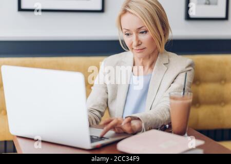 Elegante Frau spielen Computer-Spiele, während mit einer Pause im Café. Nahaufnahme Foto. Entertainment-Konzept Stockfoto