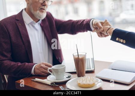 Alte Freunde schütteln Hände.unerwartete Treffen im Café. Nahaufnahme beschnitten Foto Stockfoto