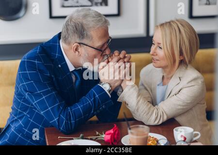 Liebevoller Mann küsst die Hände seiner Frau und zeigt sein Gefühl und Liebe. Mann dankt seiner Frau für ein glückliches Leben. Nahaufnahme Foto. Ideale Beziehung dazwischen Stockfoto