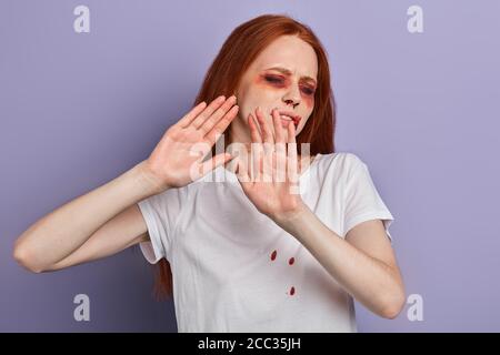 Stop verletzt Frauen Junge verprügelt verängstigte Ingwer Frau mit geschlossenen Augen, die Hand ausstreckt, während sie gegen blaue Wand stehen. Angst. fobia. Nicht berühren Stockfoto