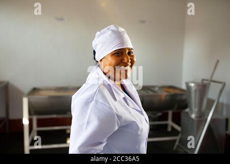 Eine in Uniform arbeitende Frau bereitet sich auf die Arbeit in einer Bananenstaub-Verarbeitungsanlage in Sullana, Peru, vor. Stockfoto