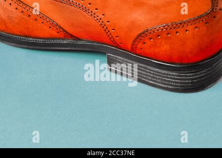 Die Ferse von Herrenschuhen auf einem farbigen Hintergrund Nahaufnahme. Herrenschuhe. Schuhverkauf. Stilvolles Accessoire aus echtem Leder. Seitenansicht mit einer Kopie von Stockfoto