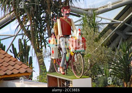 Ein Automatenlieferer fährt im Biom des Eden Project in Cornwall, England, ein Fahrrad Stockfoto