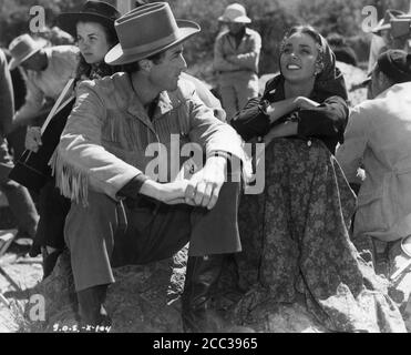 GREGORY PECK und JENNIFER JONES am Drehort offen mit Movie Crew während der Dreharbeiten zum DUELL IN DER SONNE 1946 Regisseure KÖNIG VIDOR OTTO BROWER WILLIAM DIETERLE SIDNEY FRANKLIN WILLIAM CAMERON MENZIES DAVID O. SELZNICK und JOSEF von STERNBERG Roman Niven Busch Drehbuch David O. Selznick Kostümbild Walter Plunkett Selznick International Pictures / Vanguard Films / Selznick Releasing Organization Stockfoto