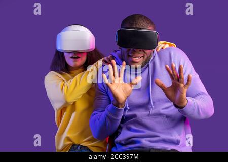 3d-Technologie, Virtual Reality, Gaming, Unterhaltung und Menschen Konzept - Angst gemischte Rennen Freunde in Virtual-Reality-Headsets schützen sich Stockfoto