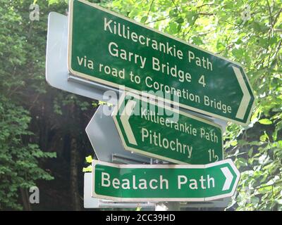 Grüne Fußwegschilder auf einem Wanderweg in der Nähe von Pitlochry: Richtungen für Killiecrankie Path, Garry Bridge, Bealach Path und 1.5 Meilen nach Pitlochry. Stockfoto
