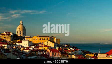 Ein Blick auf den Sonnenuntergang über dem historischen Alfama-Viertel von Lissabon, Portugal. Bild zeigt das Nationale Pantheon (die weiße Kuppel mit Blick auf die Stadt), Häuser, Stockfoto