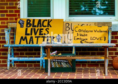 Frederick, MD, USA 08/14/2020: Auf einer alten Holzbank auf der P-Seite werden Schilder aufgestellt, die Rassendiskriminierung gegen Afroamerikaner verurteilen Stockfoto