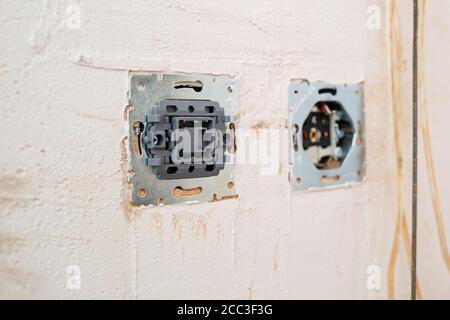 Buchsen bei Montage ohne Abdeckung. Während der Reparatur die Kabel öffnen. Europäisches Nest ohne Abdeckung isoliert auf weißem Hintergrund. Professionelle Installation Stockfoto