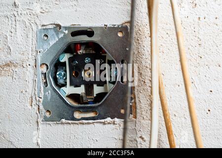 Buchsen bei Montage ohne Abdeckung. Während der Reparatur die Kabel öffnen. Europäisches Nest ohne Abdeckung isoliert auf weißem Hintergrund. Professionelle Installation Stockfoto