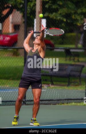 MD, USA 08/14/2020: Ein sportlicher hispanic-Mann mit schweißtreibendem ärmellosen Hemd und Shorts nimmt während eines Tennisspiels auf einem lokalen Tennisplatz in Ba eine Aufschrift auf Stockfoto