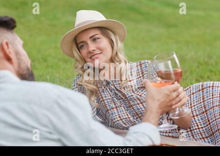 Portrait der schönen blonden Frau hält Weinglas beim Picknick Auf grünem Gras während romantischen Date im Freien Stockfoto