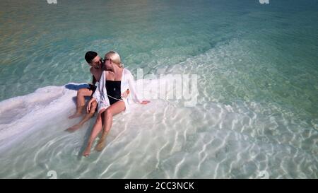 Luftbild der schönen Modelle leidenschaftliche Paar küssen und umarmen im Meerwasser. Dead Sea Israel Stockfoto