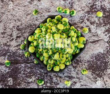 Blick von der Spitze eines Avocado Smash auf ein Schwarzer Teller mit pochierten Eiern Tomaten und Basilikumblättern Stockfoto