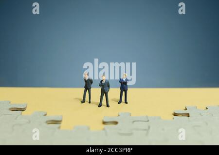 Business-Strategie konzeptuelles Foto - Gruppe von Miniatur-Geschäftsmann stehend Auf Holztisch vor dem fehlenden Puzzleteil Stockfoto