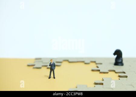 Konzeptionelle Fotos von Geschäftsstrategien - Miniatur Menschen Geschäftsleute stehen Vor unvollständigen Puzzles Stockfoto