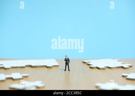Konzeptionelle Fotos von Geschäftsstrategien - Miniatur Menschen Geschäftsleute stehen Vor unvollständigen Puzzles Stockfoto