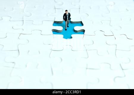 Business-Strategie konzeptionelle Foto - Miniatur Geschäftsmann zu Fuß in fehlt Puzzleteil Stockfoto