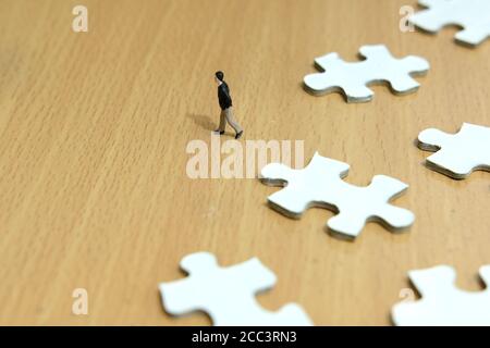 Business-Strategie konzeptionelle Foto - Miniatur Geschäftsmann zu Fuß vor Des fehlenden Puzzles Stockfoto