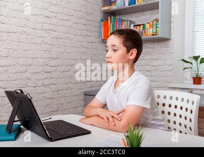 Schuljunge studiert zu Hause und macht Schulaufgaben. Heimschooling Stockfoto